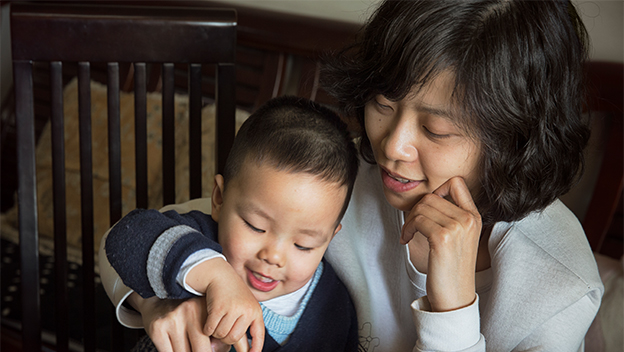 Mother and child playing a piano