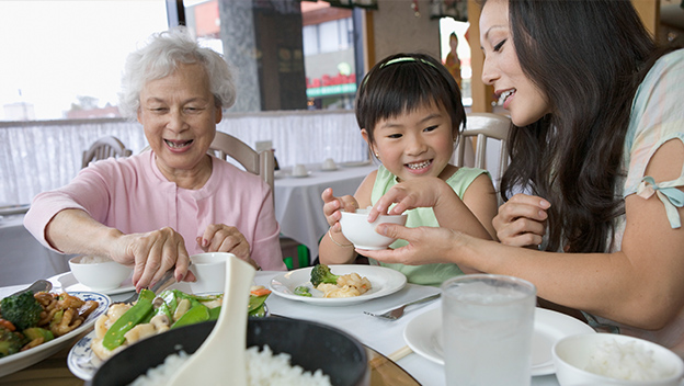 Grandmother sharing meal with family.